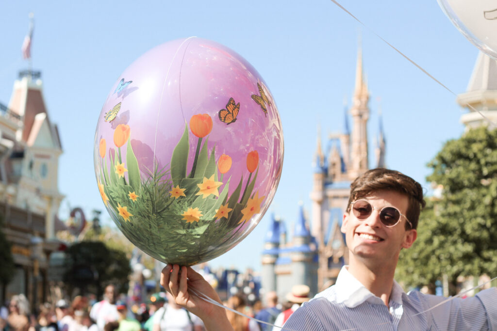 Rubio Arts cast member holding a new spring balloon on Main Street, U.S.A. at Magic Kingdom