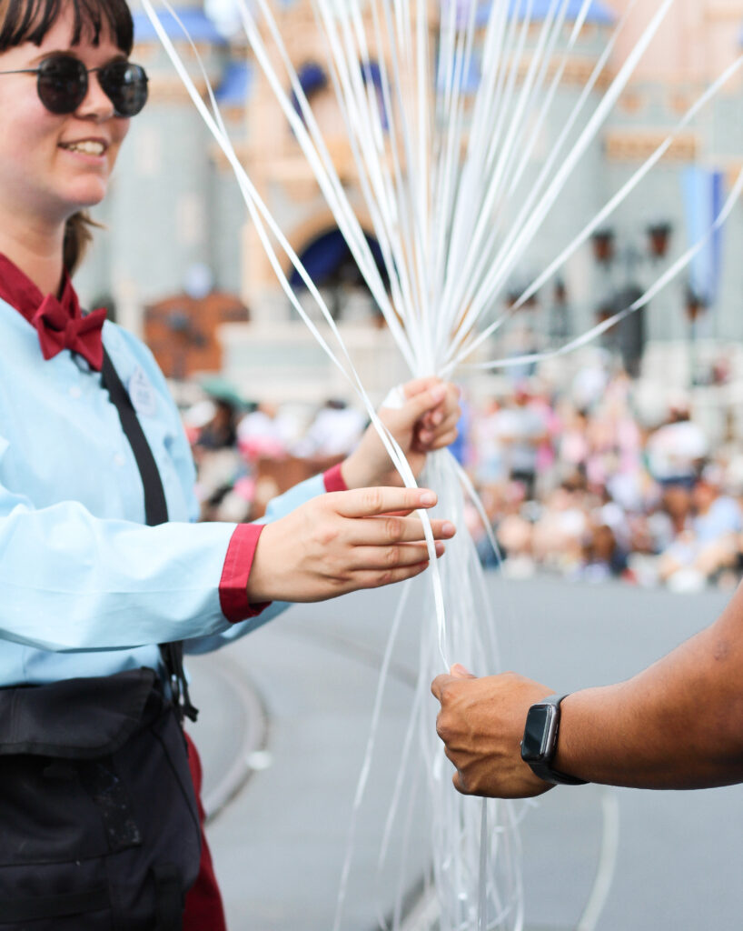 Rubio Arts balloon vendor handing a balloon to a guest at Walt Disney World