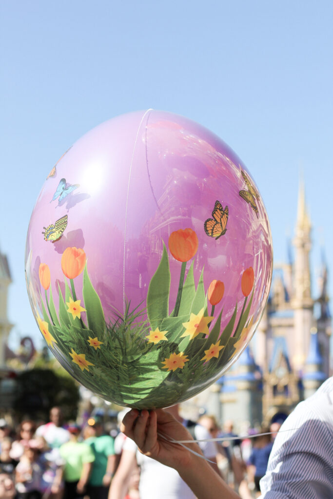 Rubio Arts cast member holding a new spring balloon on Main Street, U.S.A. at Magic Kingdom