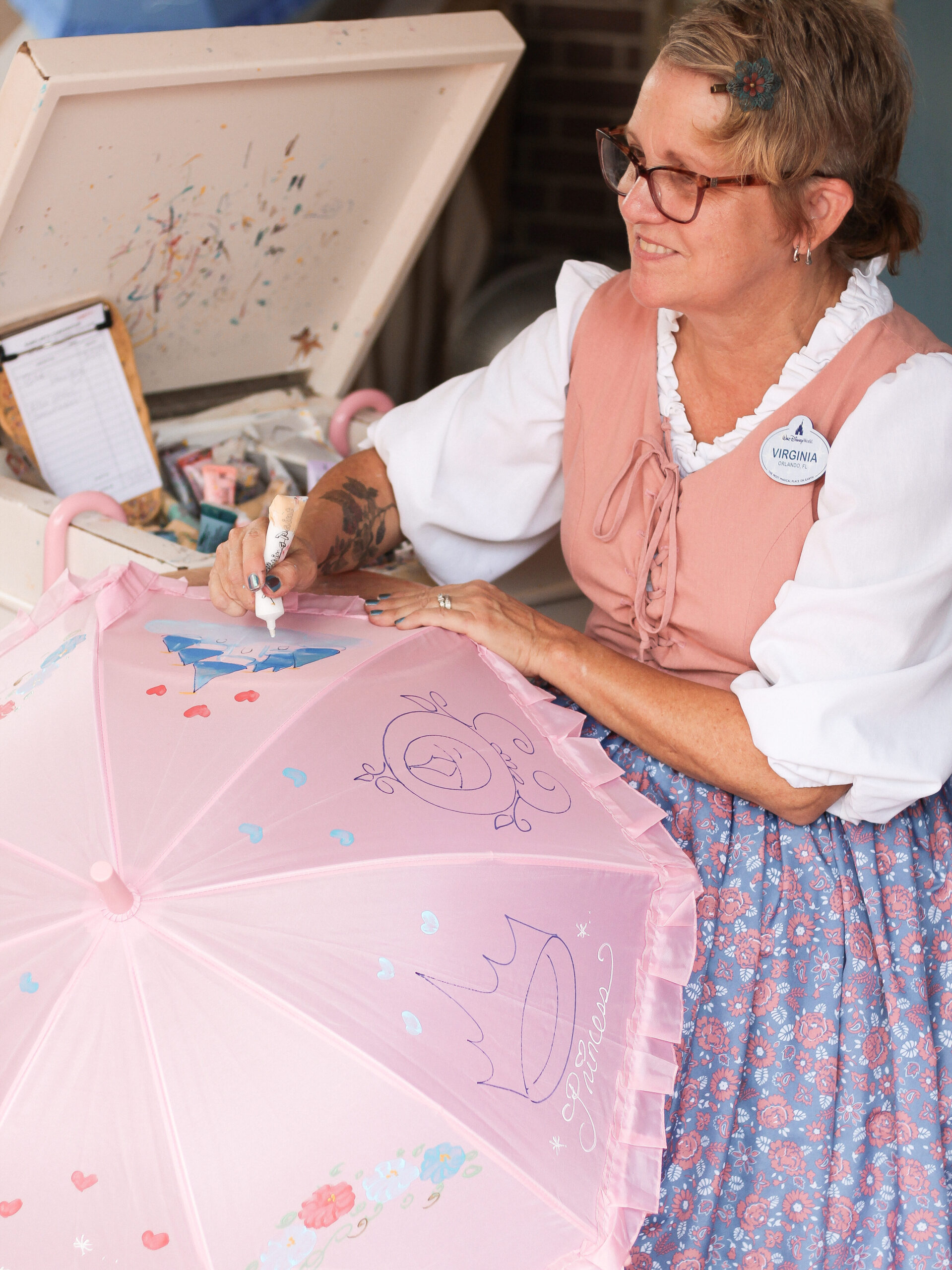 Walt Disney World artist Virginia painting parasols at Magic Kingdom