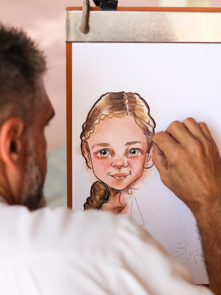 Caricature and portrait artist Elias sketching a caricature of a young girl at Magic Kingdom