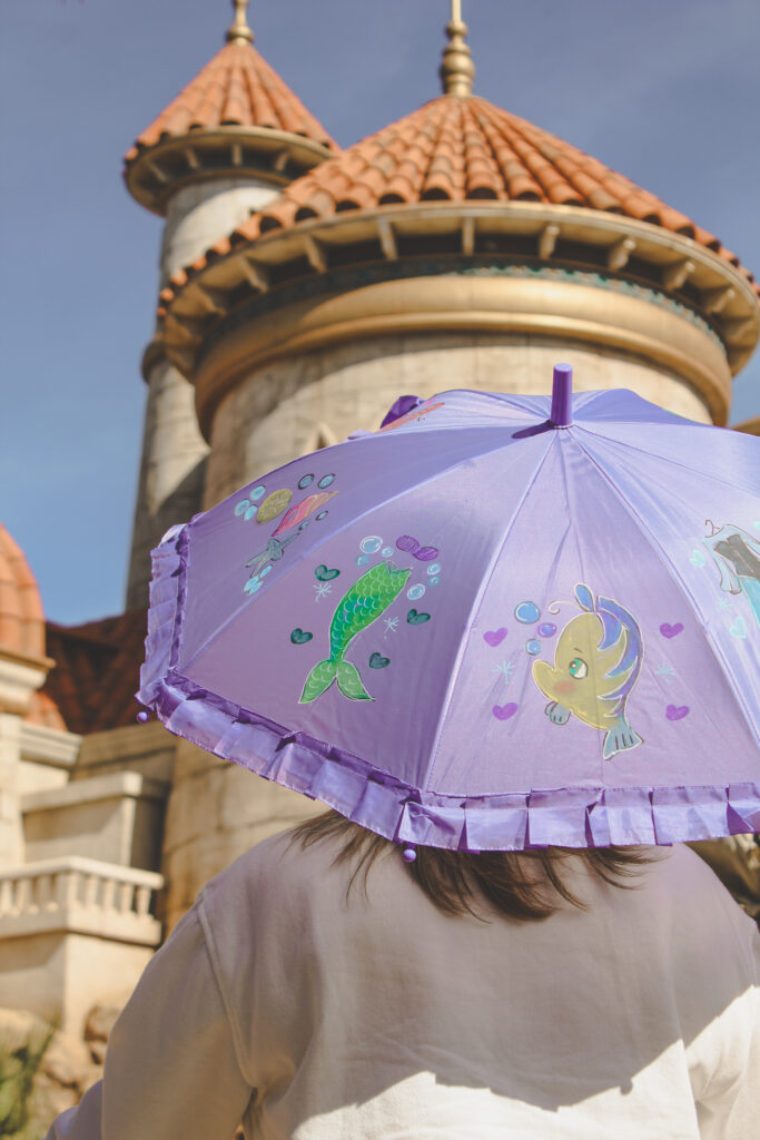 A purple Magic Kingdom parasol inspired by Ariel from The Little Mermaid