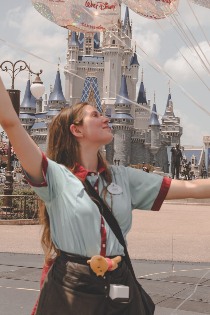 Walt Disney World balloon vendor cast member in front of Cinderella Castle's new paint